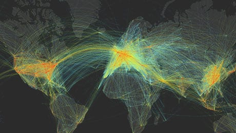 Linee colorate ad arco che mostrano il flusso del traffico aereo su una mappa del mondo