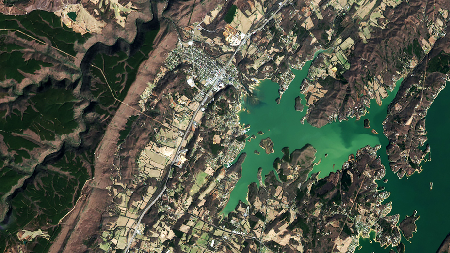 Un'insenatura costiera si snoda oltre le montagne per raggiungere un'area densamente popolata e i vicini terreni agricoli