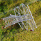 Aerial view of a powerline with brush and green trees underneath it