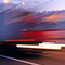 A semi-truck driving on the highway with blurred multicolored lights to indicate fast movement