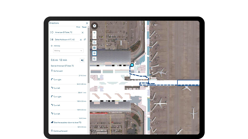 Uno schermo di un tablet che mostra una ripresa dall'alto di un terminal di un aeroporto con indicazioni passo-passo sulla sinistra