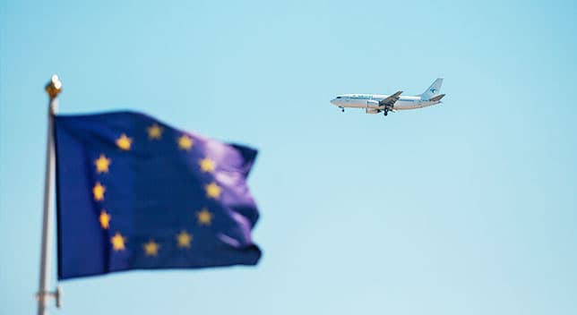 Un aereo nel cielo che vola sopra una bandiera blu 
