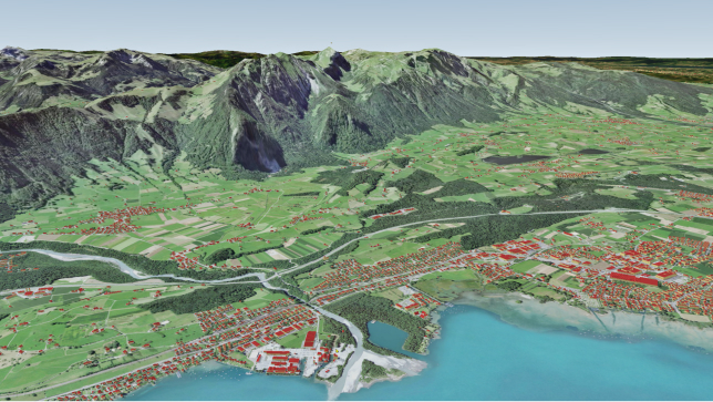 Un paesaggio virtuale in 3D che riproduce una montagna, una pianura verde e il litorale con edifici rappresentati in forma di poligoni rossi.
