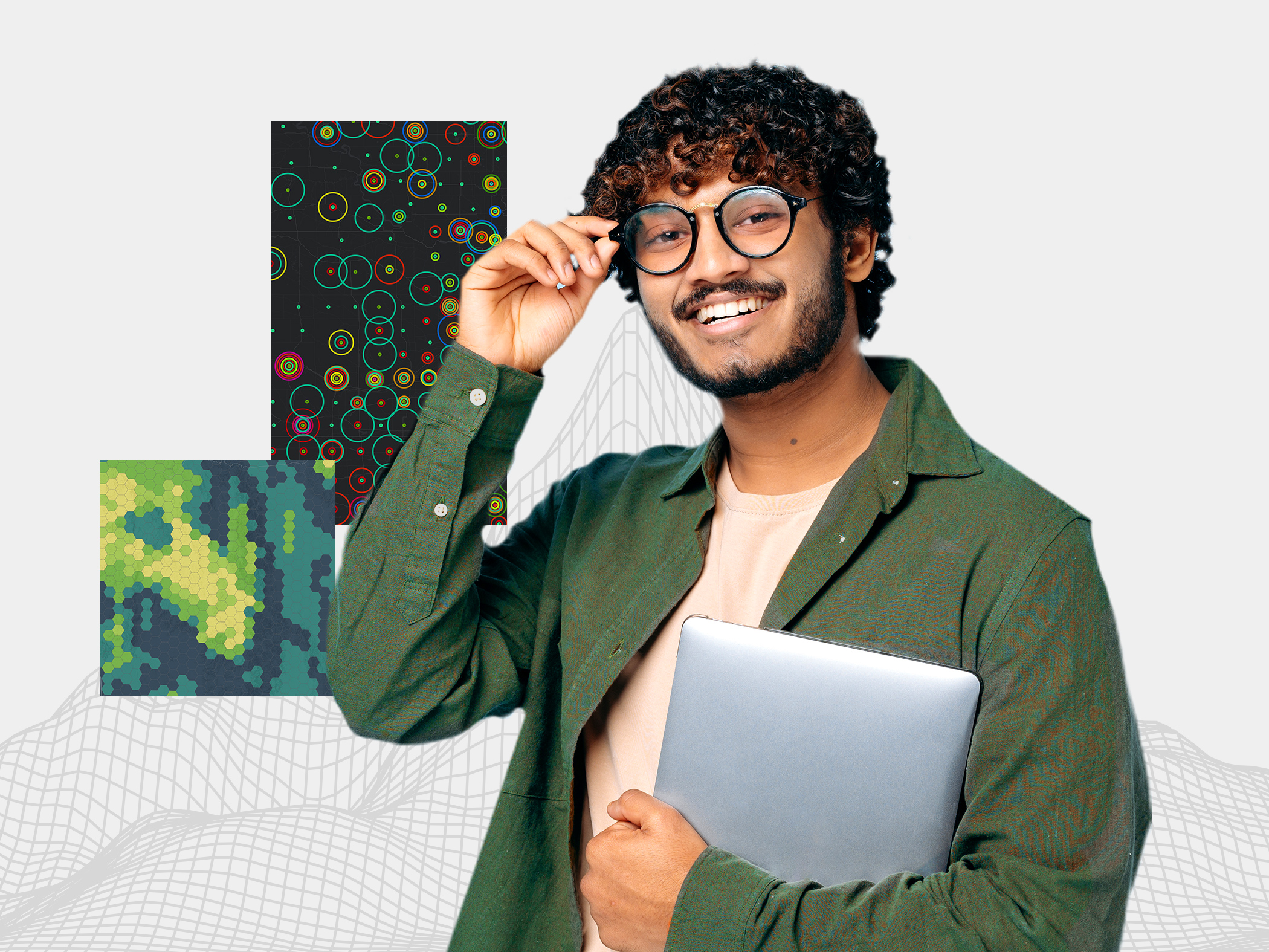 A person wearing glasses and a green long-sleeved shirt smiles while holding a laptop, against a background of various maps