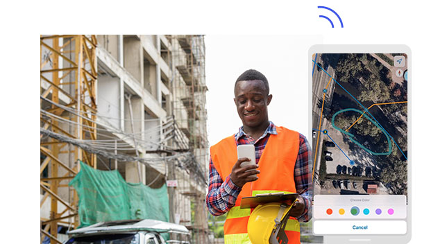 Addetto sul campo che tiene in mano un telefono cellulare, un casco e un portablocco in un cantiere. Screenshot da telefono con l'area cerchiata in verde.