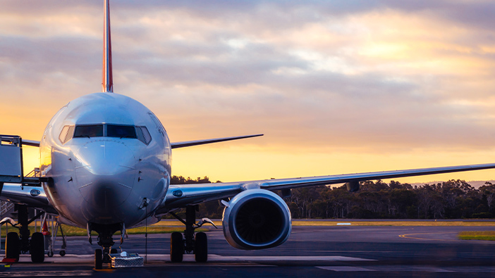 Fronte di un aereo commerciale su una pista al crepuscolo