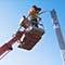 Photo of a maintenance technician on a crane fixing a street light 