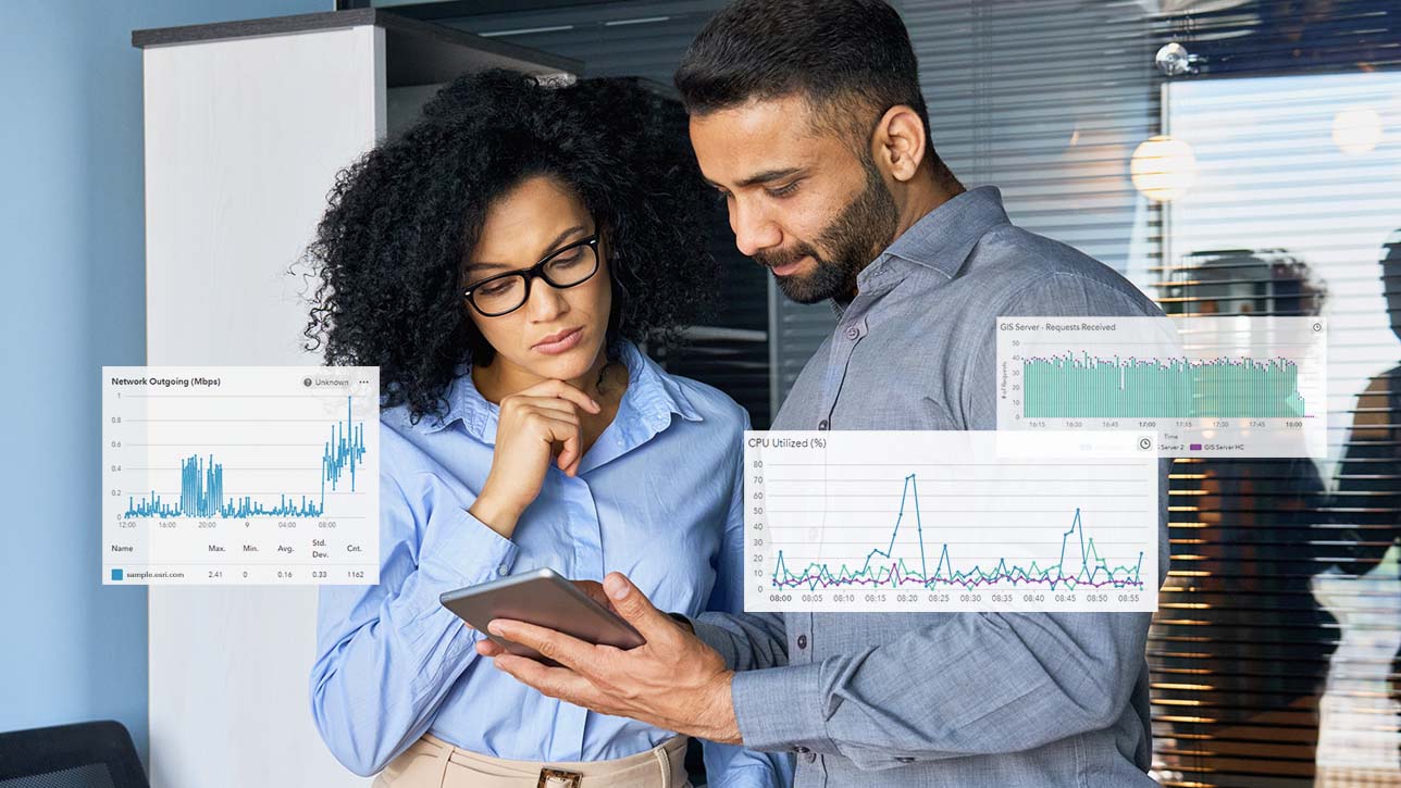Un uomo e una donna nella stanza di un server che guardano un tablet con disegni di grafici a linee sovrapposti nell'immagine 