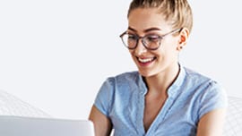 Giovane donna con gli occhiali che usa un computer portatile