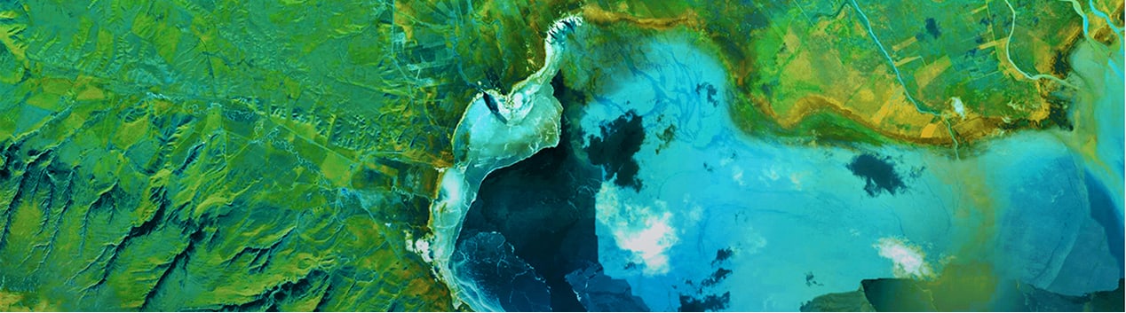 Aerial view of a shipping port with multiple cargo ships docked, their large structures and containers visible in vibrant colors