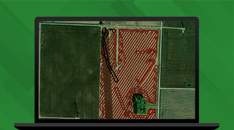 Grafica di un monitor di laptop che mostra una mappa modello di un campo verde con una griglia rossa, su uno sfondo verde