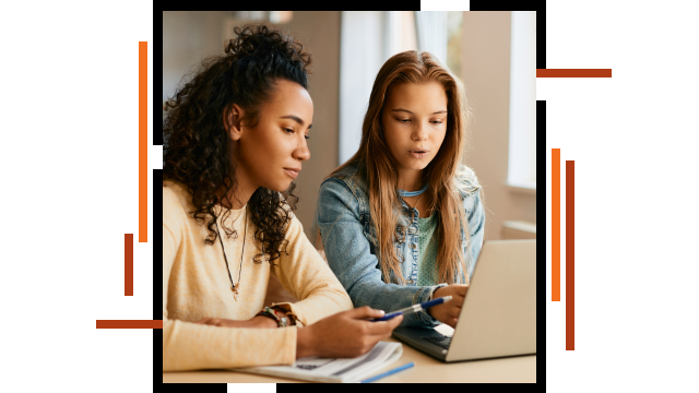 Due persone sedute a una scrivania che guardano uno schermo di un laptop