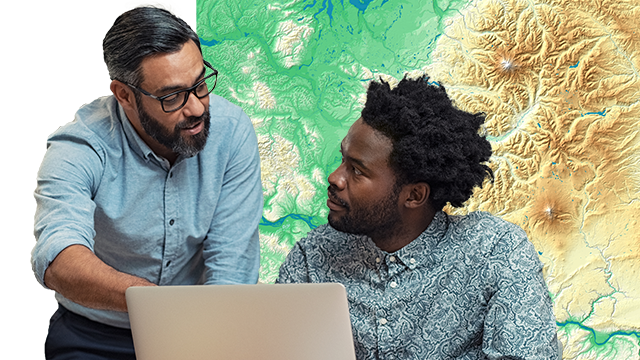 Two people talking about a map on a laptop while one of them is pointing toward the laptop screen, and a map background