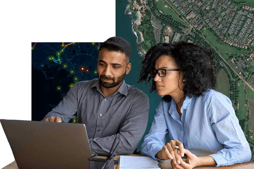 Two people sitting at a desk looking at a laptop, and a map background