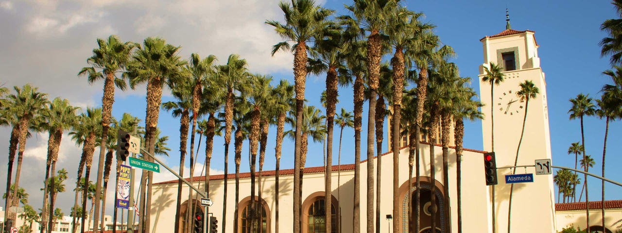 Los Angeles Union Station on a clear day with palm trees and a deep blue sky.